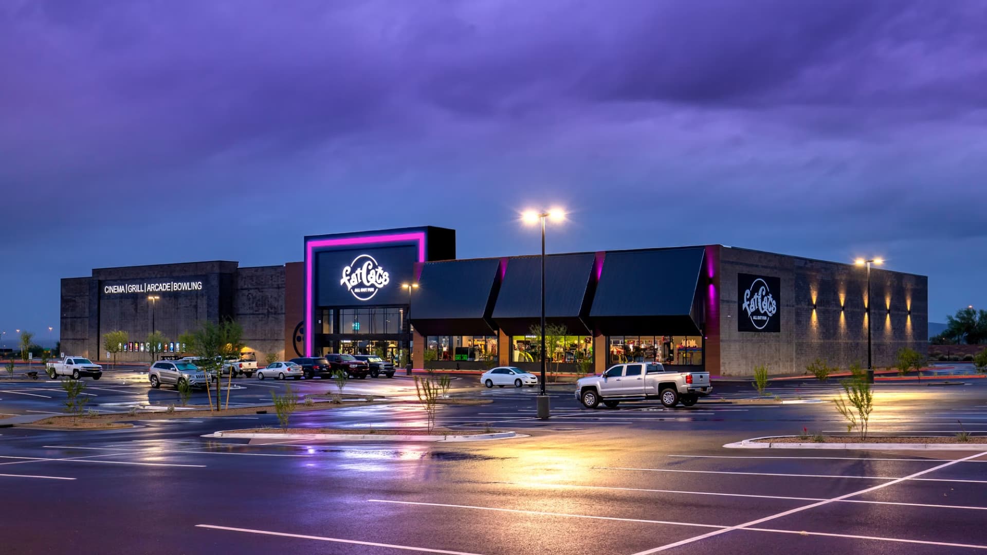 Illuminated exterior of FatCats entertainment center at dusk, featuring bright neon signage and channel letters.